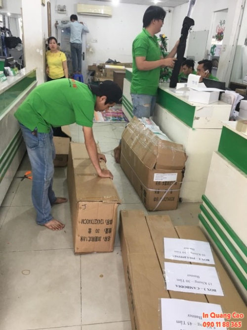Nhân viên giao nhận đóng gói đơn hàng in quảng cáo khổ lớn trước khi giao hàng in